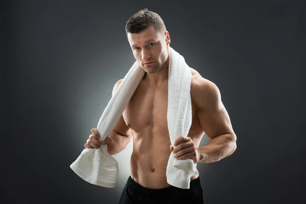 Мускулистый мужчина держит полотенце — стоковое фото