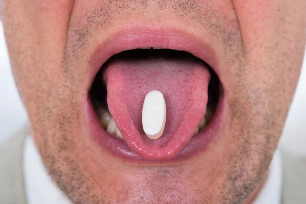 Man With Medicine On Tongue — Stock Photo, Image