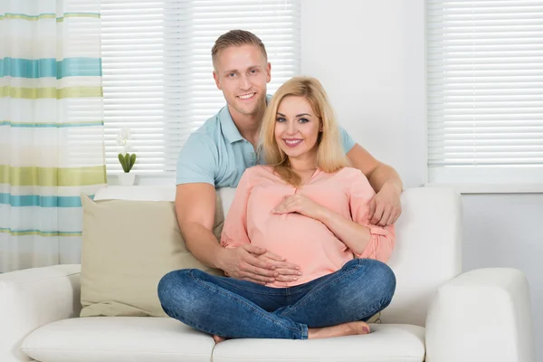 Esperando casal sentado no sofá — Fotografia de Stock