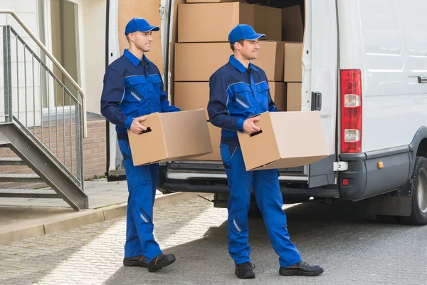 Homens de entrega transportando caixas de papelão — Fotografia de Stock