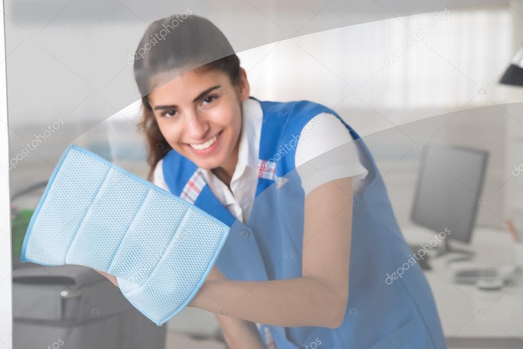 Happy Female Worker Cleaning Glass