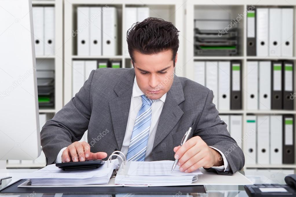 Accountant Calculating Bills At Desk