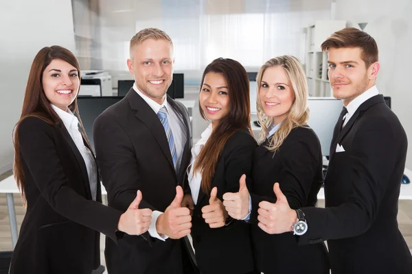 Glückliche Geschäftsleute gestikulieren mit erhobenem Daumen — Stockfoto