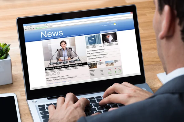 Businessman Reading News On Laptop At Desk — Stock Photo, Image