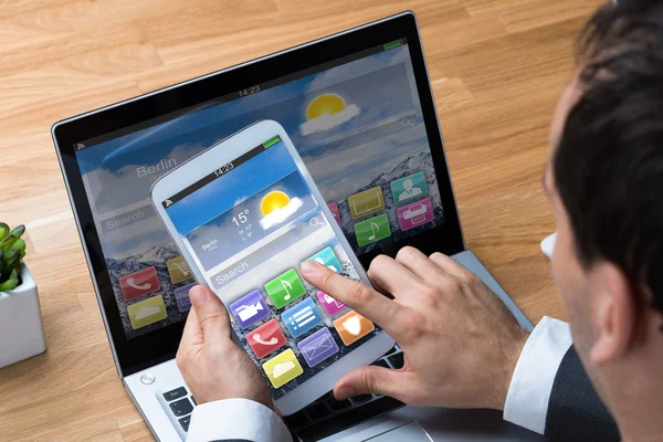 Empresario usando smartphone y laptop — Foto de Stock