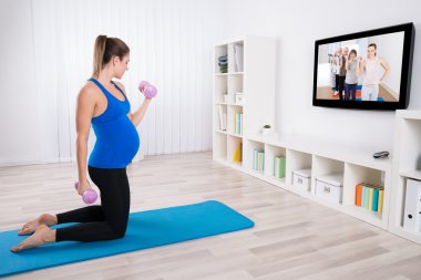 hamile kadın dumbbells ile egzersiz yaparak