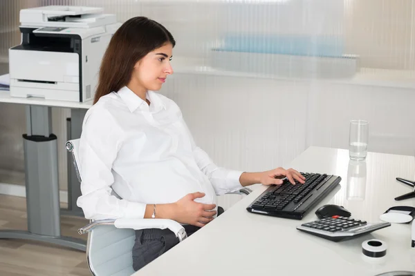 Embarazada mujer de negocios utilizando la computadora —  Fotos de Stock