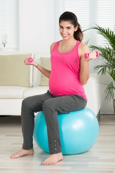 Mujer embarazada levantando pesas — Foto de Stock