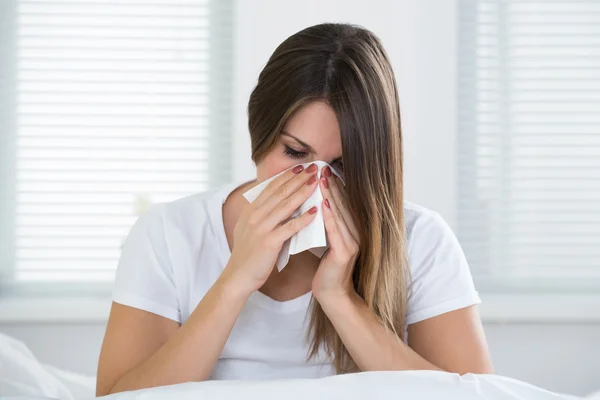 Mujer con resfriado sonándose la nariz — Foto de Stock