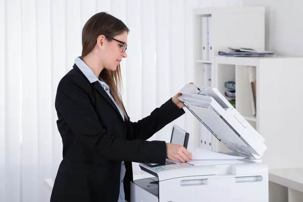 Предпринимательница с помощью печатной машины — стоковое фото