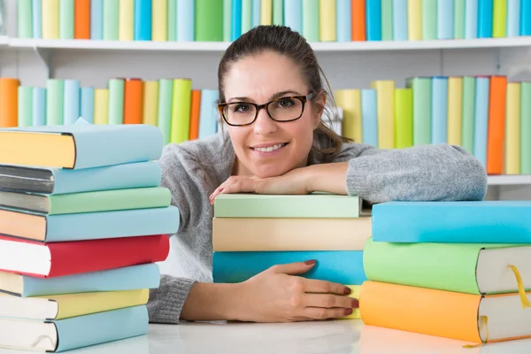 Femme s'appuyant sur les livres au bureau — Photo