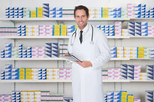 Αρσενικό φαρμακοποιός κρατώντας αρχείο στο φαρμακείο — Φωτογραφία Αρχείου