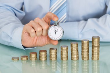Kronometre sikkeler üzerinde tutan işadamı