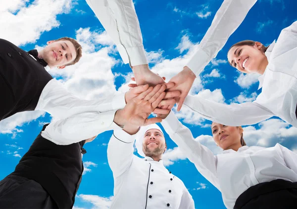 Servitörer och servitriser stapling händer — Stockfoto