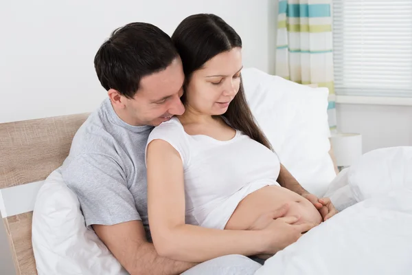 Esperando casal sentado na cama — Fotografia de Stock