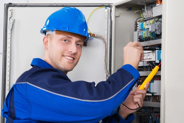 Tecnico maschio esaminando fusebox — Foto Stock