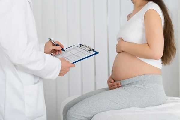 Médico con mujer embarazada — Foto de Stock