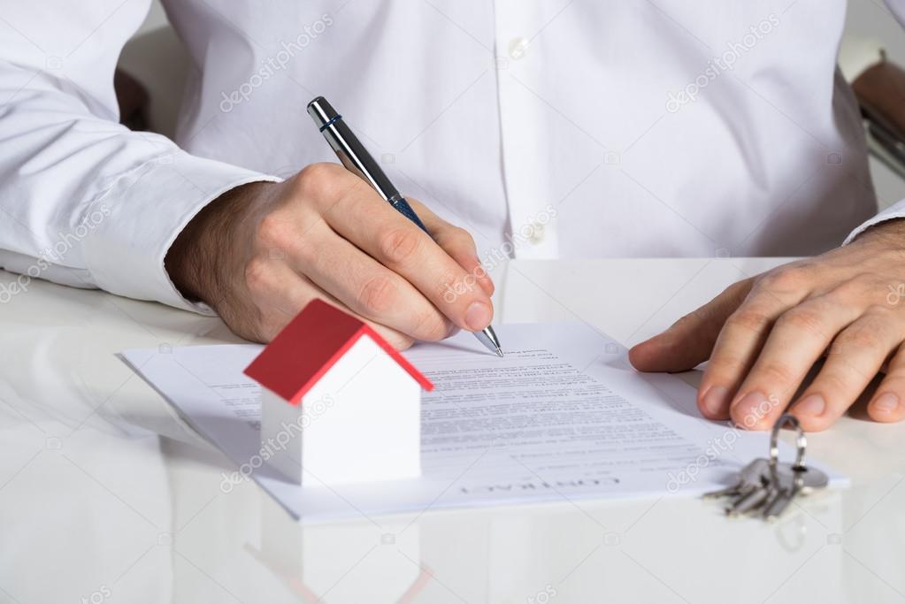 Man Signing House Contract