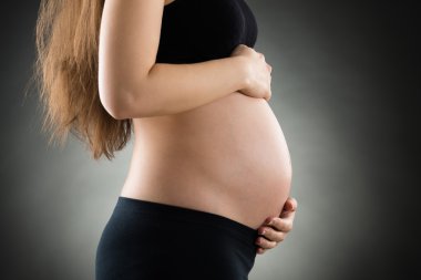 Karnını tutan hamile kadın.