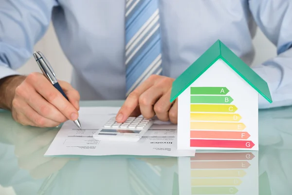 Empresário calculando a taxa de eficiência energética — Fotografia de Stock