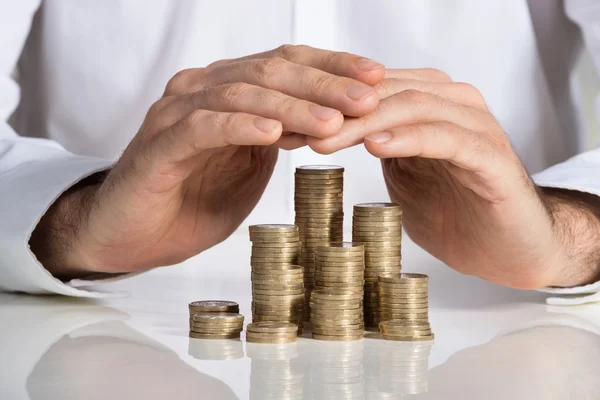 Businessman Protecting Stacked Coins — Stock Photo, Image