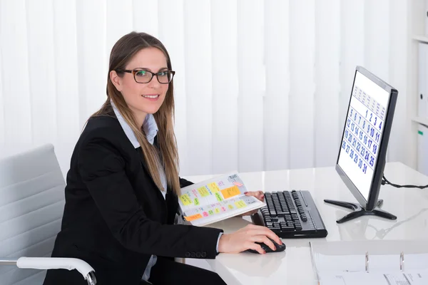 Femme d'affaires avec journal intime regardant l'ordinateur — Photo