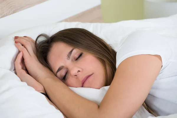 Jonge vrouw slaapt in de slaapkamer — Stockfoto