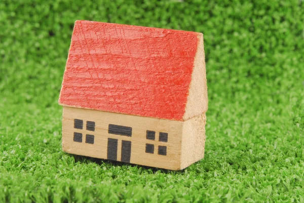 Miniatuur huis op groene gras concept — Stockfoto