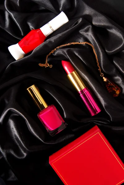 Lipstick and nail polish on black fabric — Stock Photo, Image