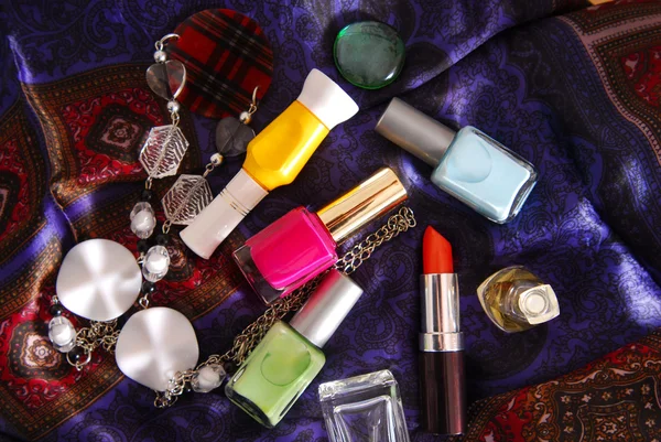 Close up of the nail polish and accessory on silky scarf — Stock Photo, Image
