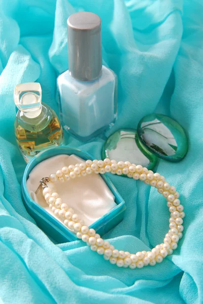 Parfum en armband op blauwe sjaal — Stockfoto