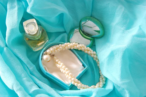 Parfum en armband op blauwe sjaal — Stockfoto