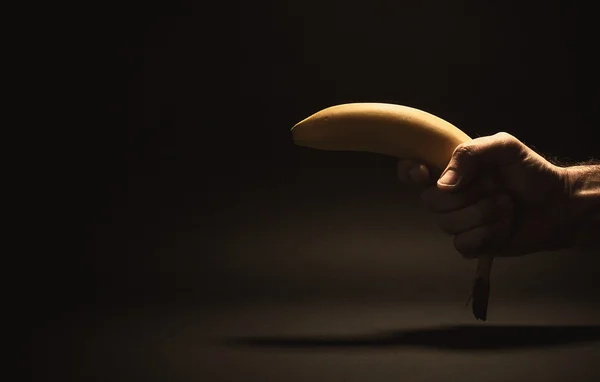 Main masculine tenant une banane — Photo