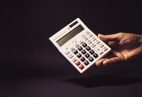 Mano masculina sosteniendo una calculadora electrónica — Foto de Stock