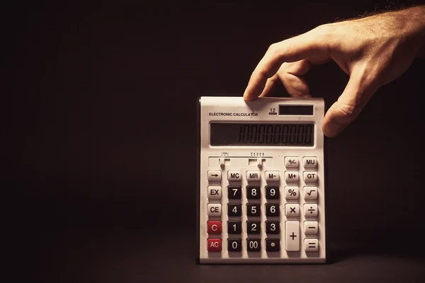 Mano masculina sosteniendo una calculadora electrónica — Foto de Stock
