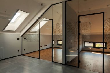 Modern ofislerin, duvarların ve kapıların içi camdan yapılmış, bir binanın çatı katı.. 