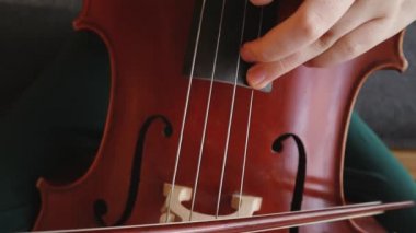 Çelloda en yüksek tonda çalıyor. Yavaş çekim. 