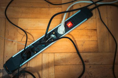 Zeminde birden fazla tıkacı olan uzatma kablosu.