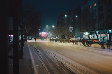 Cacak, Sırbistan - 07 Ocak 2026: Şehir caddesi ilk kar, gece manzarasıyla kaplı.