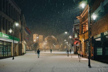 Cacak, Sırbistan - 07 Ocak 2026: Şehir caddesi ilk kar, gece manzarasıyla kaplı.