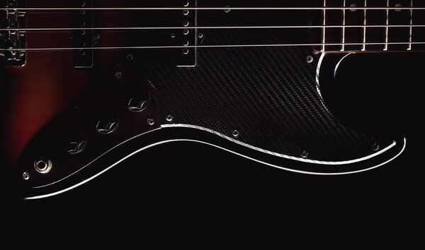 Part of a jazz bass guitar, accentuated shapes with illumination.