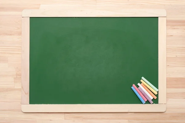 Krijtbord met kleurpotloden — Stockfoto