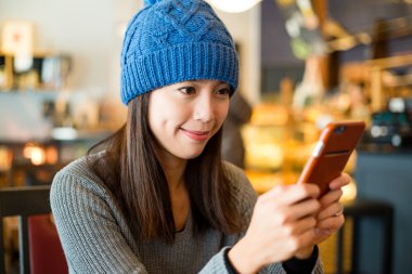 kahve dükkanında cep telefonu kullanan kadın