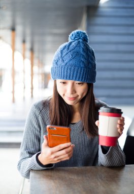 Cep telefonu kullanarak kahve ile Asyalı kadın