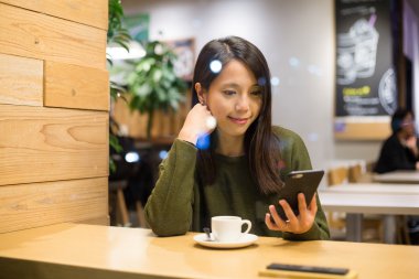 Café'de cep telefonu kullanan kadın