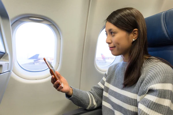 Mujer usando el teléfono móvil en el avión — Foto de Stock