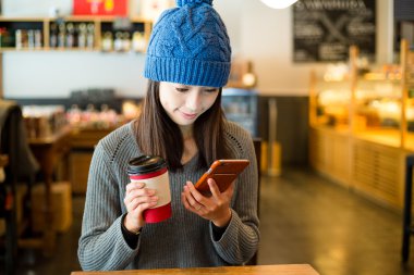 cep telefonu kapalı kahve dükkanında bakarak kadın