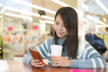 kahve dükkanında cep telefonu kullanan kadın