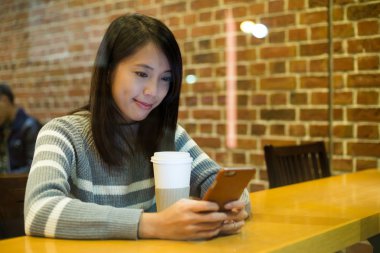 Kafede akıllı telefon kullanan kadın
