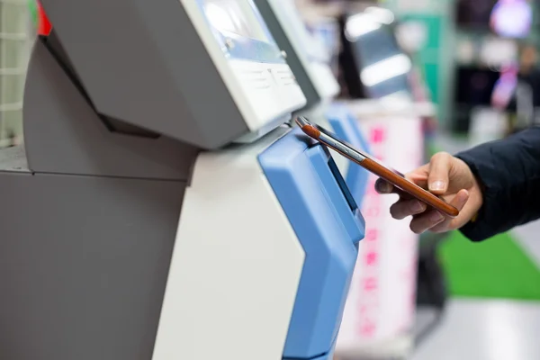 Mujer pagando en la máquina de venta de billetes por teléfono celular — Foto de Stock